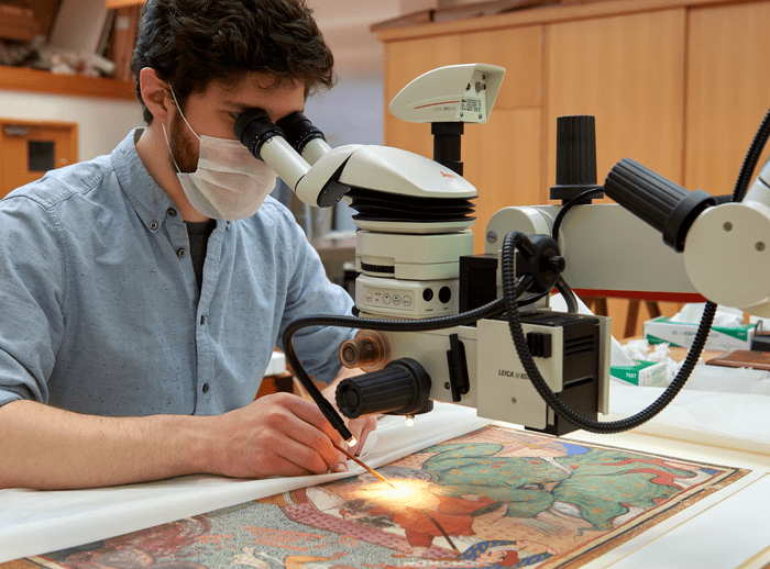Matthias Sotiras, conservator of pictorial art, consolidating a Mughal painting