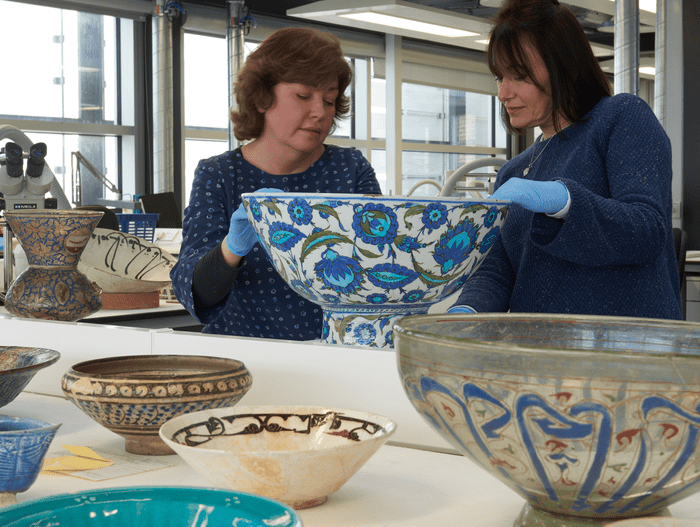 Glass and ceramics conservators Denise Ling (left) and Loretta Hogan (right) assessing an Iznik basin