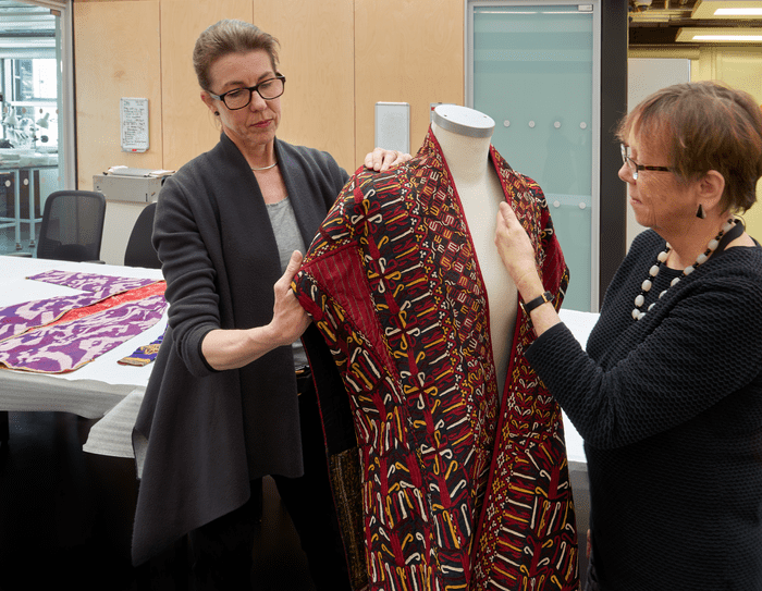 Textile collection managers Imogen Laign (left) and Helen Wolfe (right) working on Central Asian costume